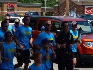 Police Officer in Parade Running with Group of People